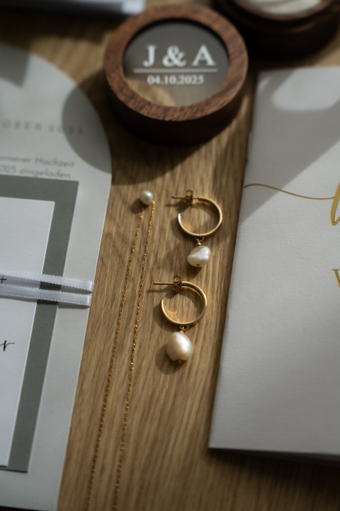 Hochzeitsringe, Brautschmuck und Papeterie in natürlichem Licht fotografiert – authentische Hochzeitsfotografie Niederösterreich